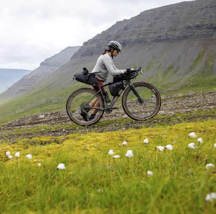 Lael moving her bike up a steep hill